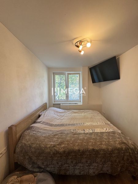 Schlafzimmer in einer 3-Zimmer-Wohnung mit Bett, Fernseher und Deckenleuchte.