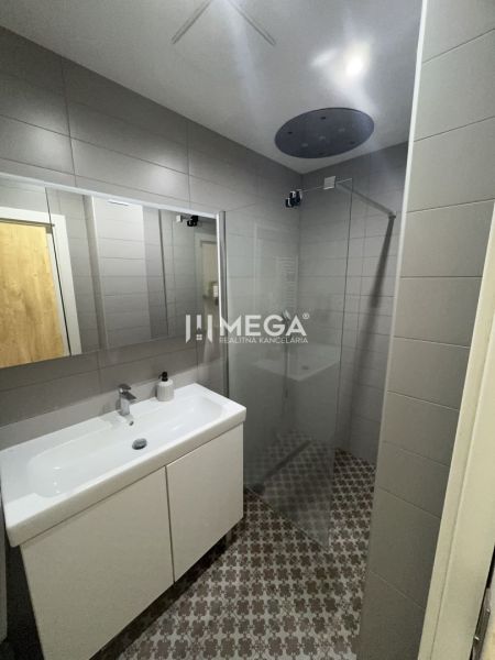 Badezimmer in einer 3-Zimmer-Wohnung mit Duschkabine, Waschbecken und gemustertem Boden.