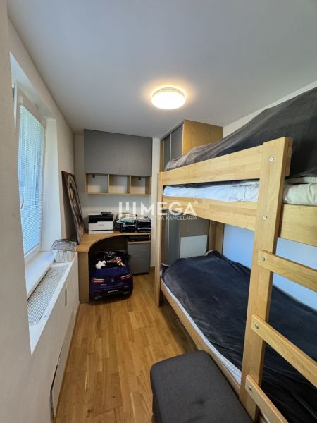 Etagenbett, Schreibtisch und Boden mit Holzdekor in einer 3-Zimmer-Wohnung.