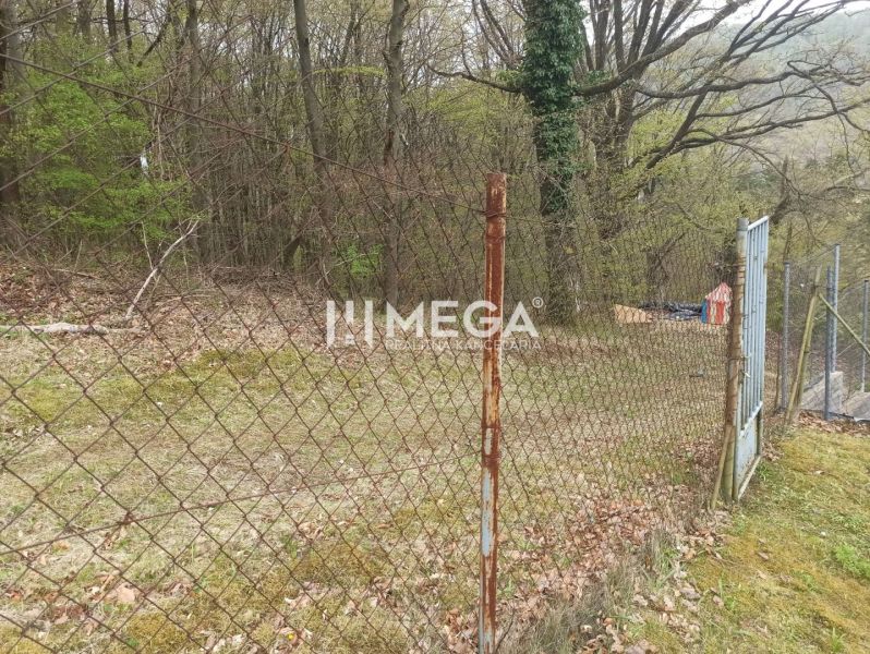 Ein Holzzaun im Garten an der Straße in Humenné, umgeben von Bäumen.