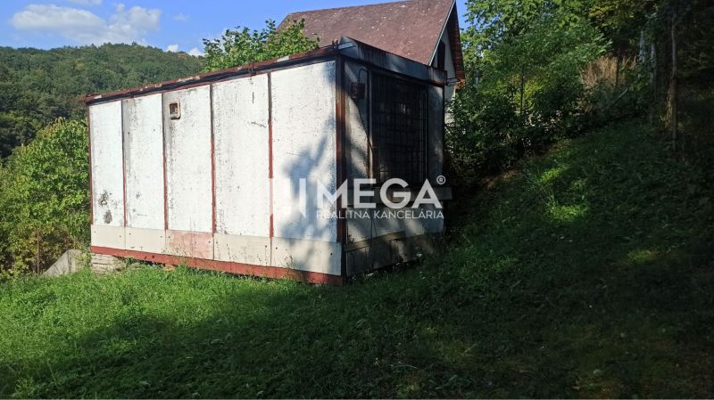 Ein Häuschen mit schrägem Dach, umgeben von Grün in den Gärten in Humenné.