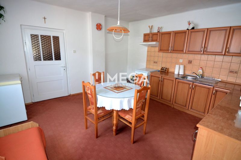Eine Küche in einem Einfamilienhaus mit Holzdekor-Schränken und einem runden Tisch.