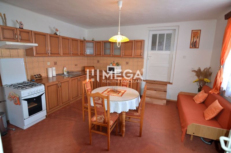 Küche in einem Einfamilienhaus mit Holzschränken und Esstisch.