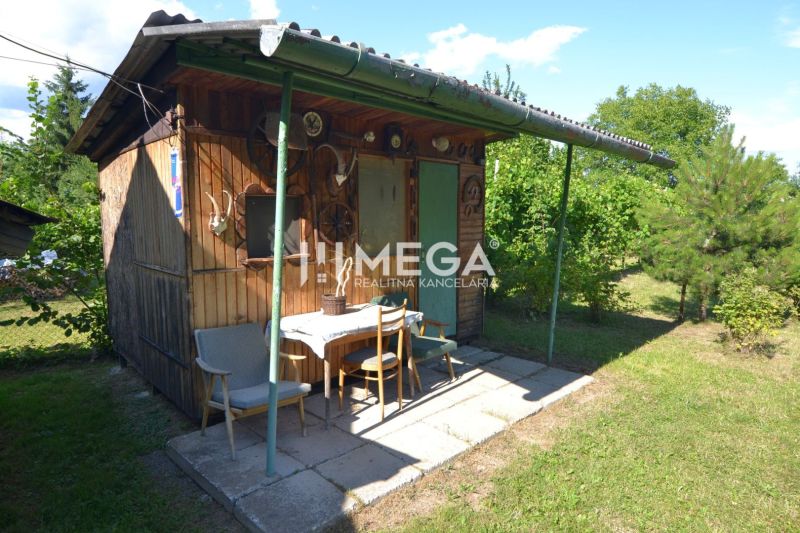 Kleines Holzgartenhaus mit Überdachung im Garten eines Einfamilienhauses in Hažín nad Cirochou.