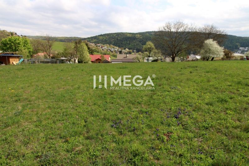 Grünflächen auf Wohnbaugrundstücken in der Brestovská-Straße in Humenné mit Blick auf die Hügel.