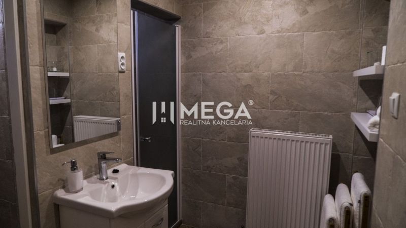 Badezimmer mit Dusche, Waschbecken und Heizkörper, ideal für Hotels und Pensionen.