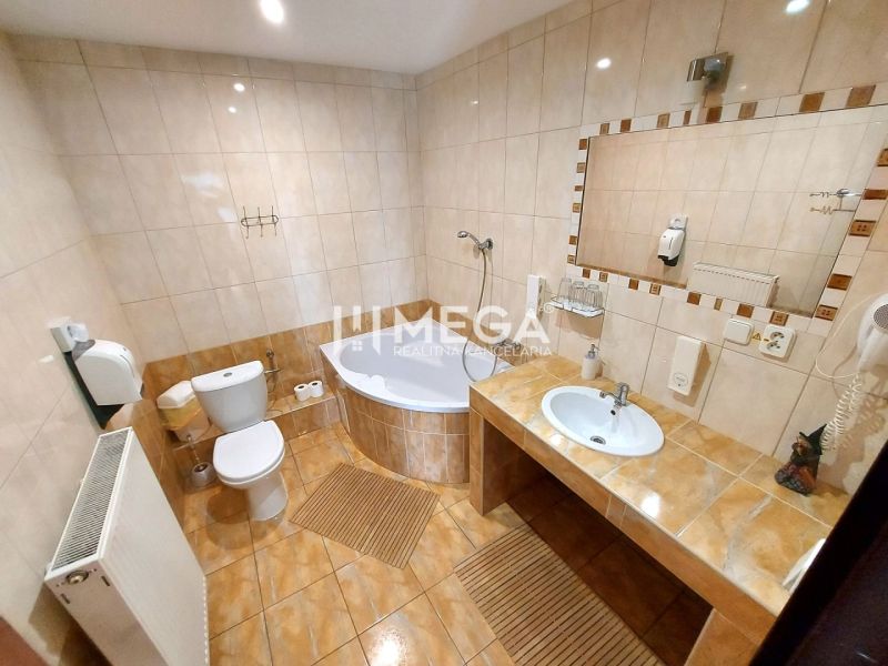 Badezimmer in Hotels und Pensionen mit Badewanne, Toilette und großem Spiegel.