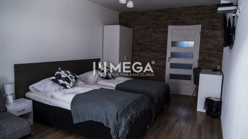 Ein Zimmerinterieur mit zwei Betten, eine Wand mit Steindekor, ein Boden mit Holzdekor.