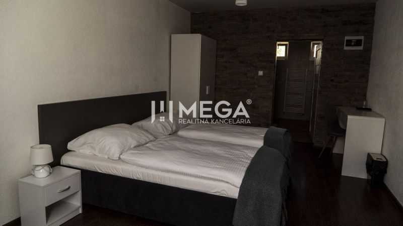Ein Zimmer mit zwei Betten, einem Tisch und einem Boden mit Holzdekor. Hotels und Pensionen.