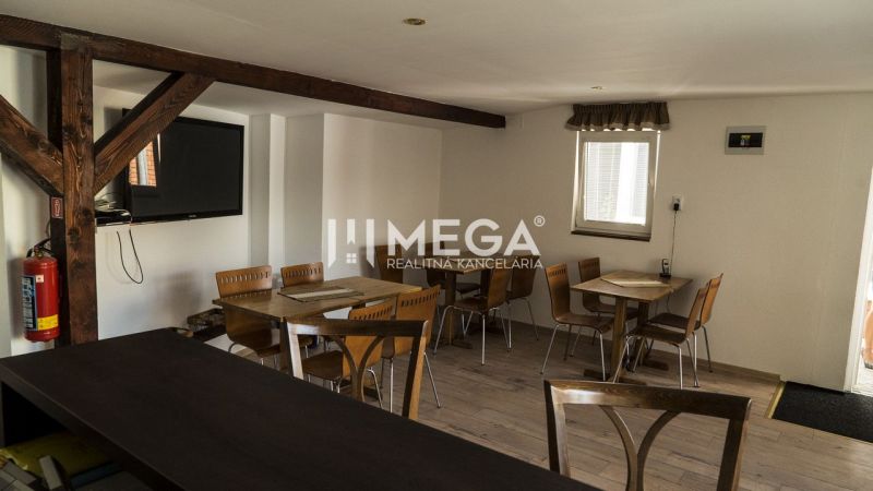 Innenraum mit Holzbalken, Tischen und Stühlen in den Gästebereichen von Hotels und Pensionen.