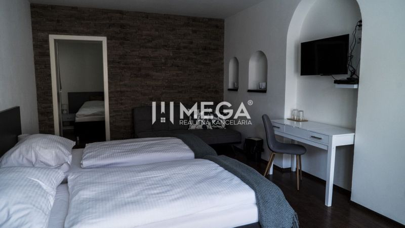 Hotelzimmer mit Fliesenwand, Boden mit Holzdekor und Schreibtisch.