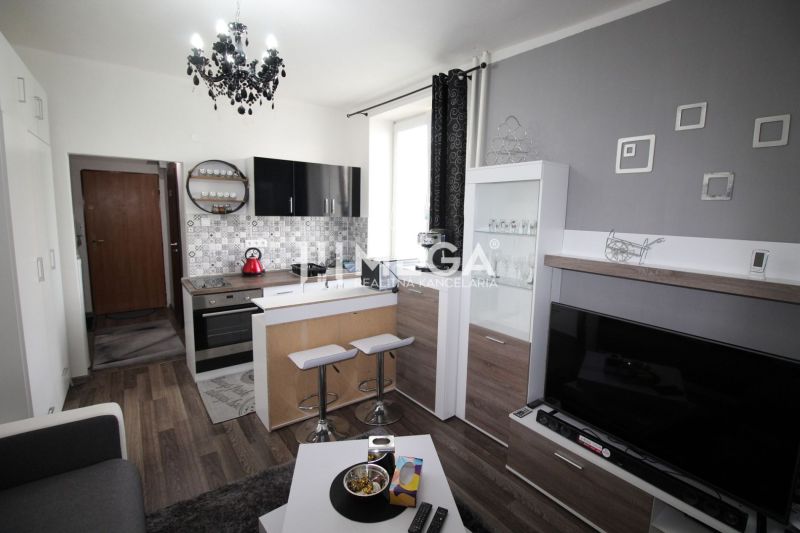 Küche in der Ferienwohnung mit Sofa und Holzboden.