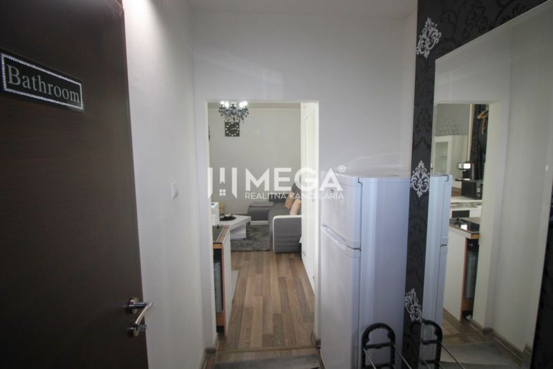 Ferienwohnung mit Holzboden, Küchenzeile und Wohnbereich.