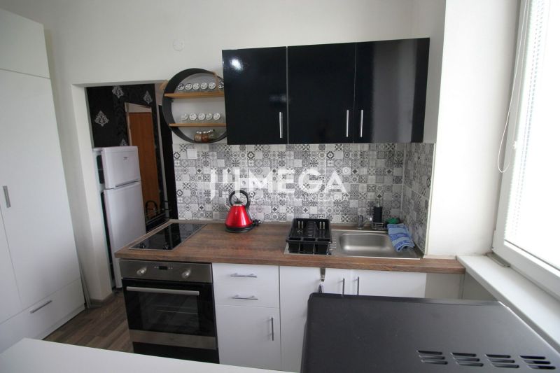 Küche in der Ferienwohnung mit Holzboden und geometrischen Fliesen an der Wand.