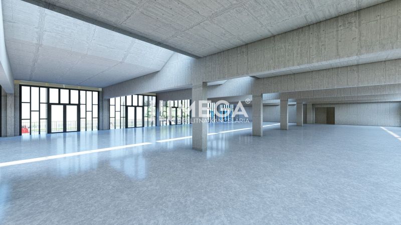 Große verglaste Halle in Geschäftsräumen mit Betonsäulen und glattem Boden.