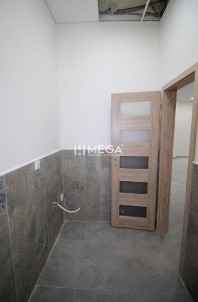 Gewerberäume mit gefliester Wand und Holztüren.