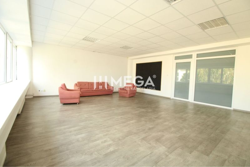 Geräumige Büros, Sofas, große Fenster und ein Boden mit Holzdekor.