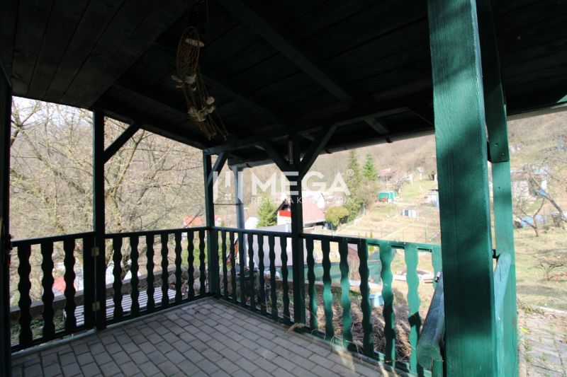 Überdachte Terrasse mit grünem Geländer in den Gärten von ZO Poniklec, Humenné.