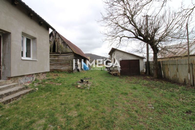 Der Garten bei einem Einfamilienhaus in der Straße in Pakostov, mit einem älteren Holzschuppen und Rasen.