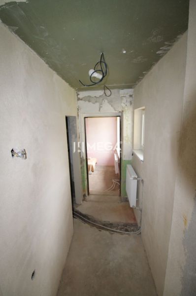 Der Flur eines im Bau befindlichen Einfamilienhauses mit verputzten Wänden und Elektroinstallationen.