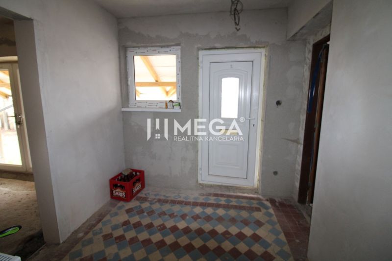 Eingang in einem Einfamilienhaus mit weißen Türen und Fliesen mit geometrischem Muster.
