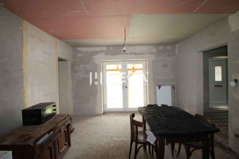 Unvollendetes Interieur mit Küchentisch, Stühlen und Schrank in einem Einfamilienhaus.