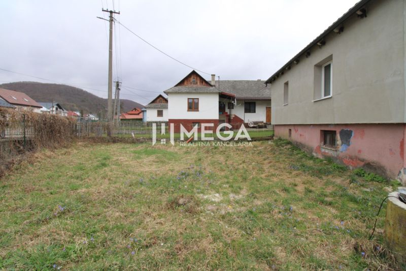 Ein Einfamilienhaus in der Pakostov-Straße in Pakostov mit einem grasbewachsenen Hof und Blick auf die Hügel.