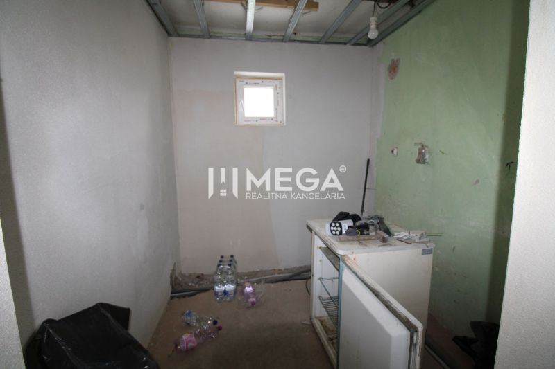 Ein Zimmer in einem Einfamilienhaus mit Fenster, eine unvollendete Wand und ein alter Tresen.