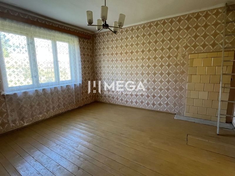 Einfamilienhaus mit Holzboden, gemusterten Tapeten und großem Fenster.