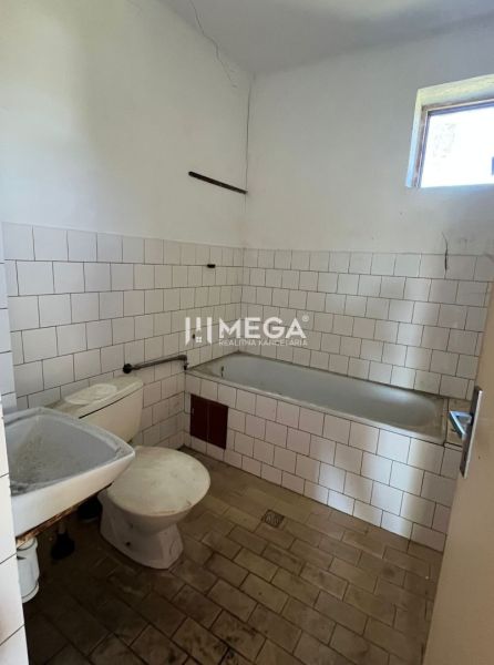 Badezimmer mit Dusche und Toilette in einem Einfamilienhaus, grundlegendes Interieur mit weißen Fliesen.