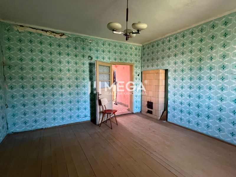 Ein Zimmer mit Tapeten in einem Einfamilienhaus mit Holzboden und Kacheln.