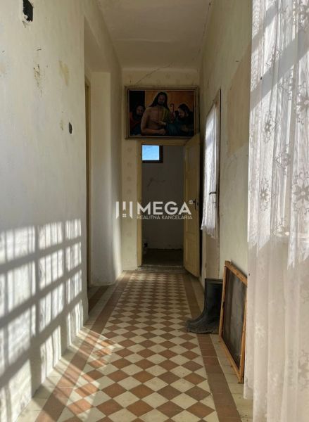 Der Flur im Einfamilienhaus mit bunten Fliesen und einem Vorhang, an der Wand hängt ein Bild.