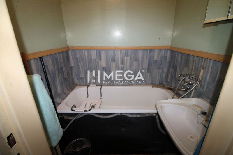Badezimmer mit Badewanne und Waschbecken in einer Zweizimmerwohnung.