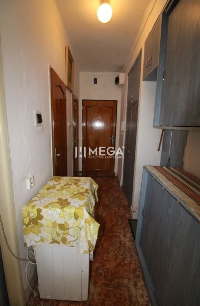 Der Flur in der 2-Zimmer-Wohnung mit einem Schrank und einem Teppich mit Blumenmuster.