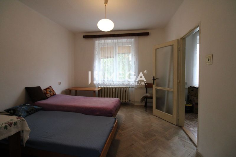 Schlafzimmer mit zwei Betten und Holzboden in einer 2-Zimmer-Wohnung.
