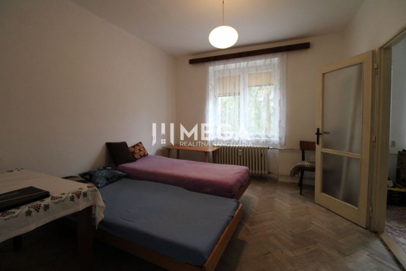 Schlafzimmer mit hellen Möbeln und Betten in einer 2-Zimmer-Wohnung mit Holzboden.