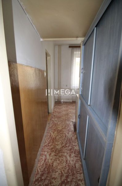 Ein enger Flur in einer 2-Zimmer-Wohnung mit Linoleum und Einbauschränken.