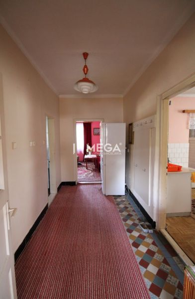 Ein Flur in einem Einfamilienhaus mit Teppichboden und einer Retro-Leuchte.