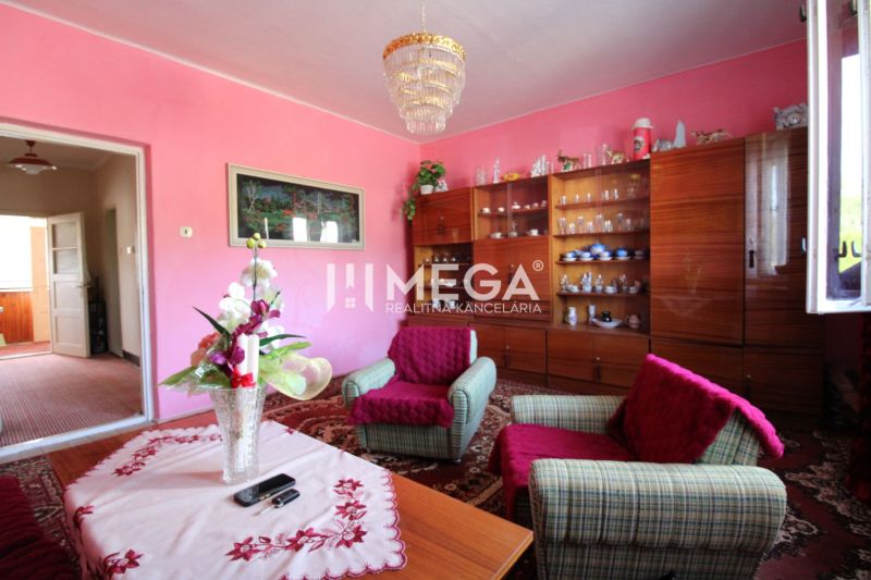 Wohnzimmer in einem Einfamilienhaus mit rosa Wänden, Möbeln und Dekorationen.