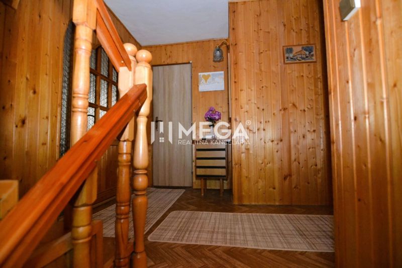 Innenraum eines Einfamilienhauses mit Treppe, Holzverkleidung und Boden mit Holzdekor.