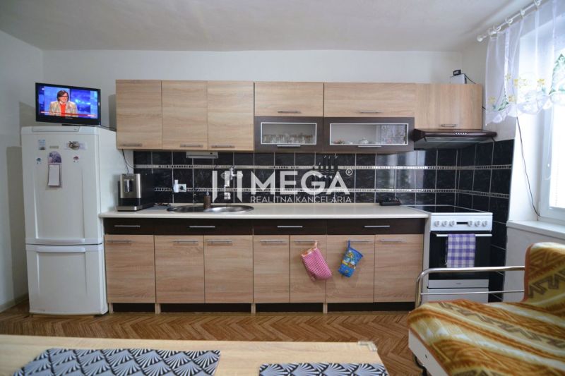 Die Küche in einem Einfamilienhaus mit Holzboden-Dekor und hellen Möbeln.