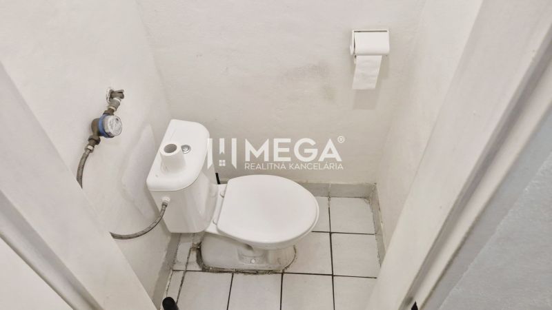 Toilette im Büro mit weißen Wänden und Keramikboden.