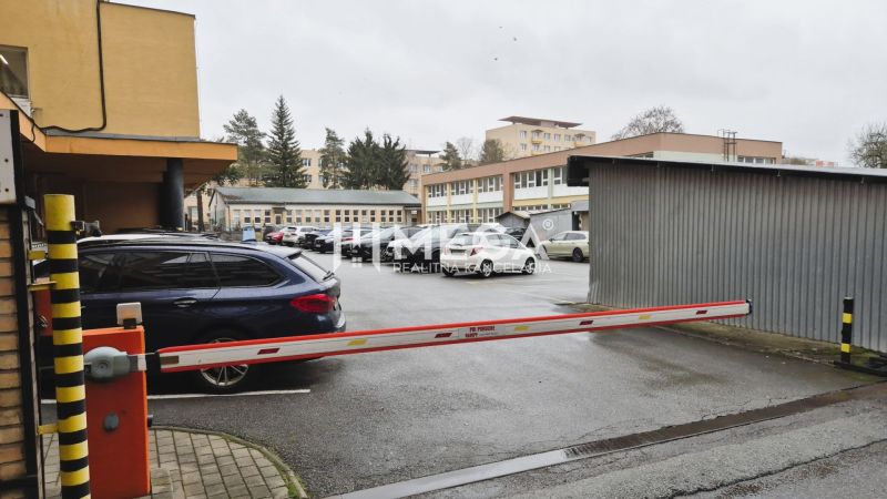 Parkplatz vor den Büros in der 26. November Straße in Humenné mit Schranke und Autos.