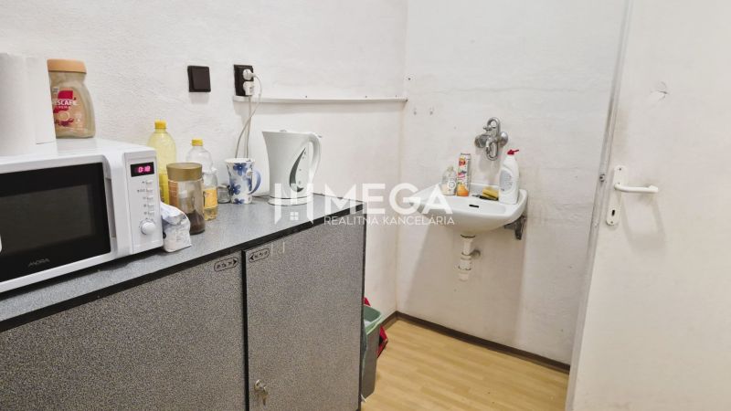 Büroräume mit Waschbecken, Mikrowelle und Bodenbelag in Holzoptik.