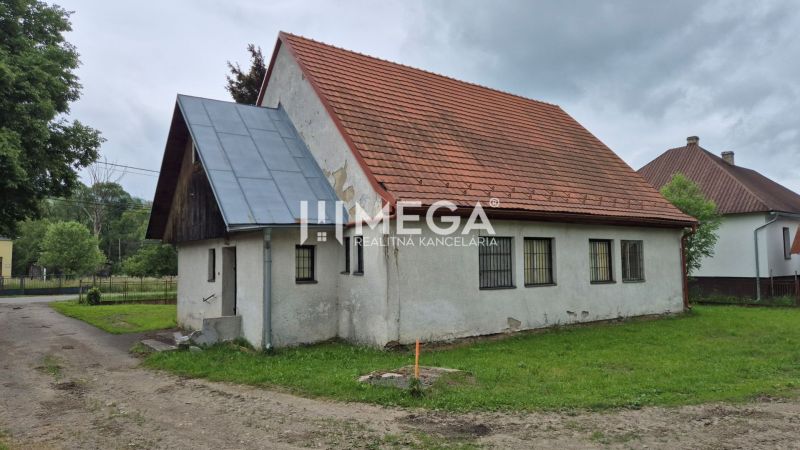Ein Gebäude mit rotem Dach in Zboj, umgeben von Grünflächen und Nachbarhäusern, nutzbar als Geschäftsräume.