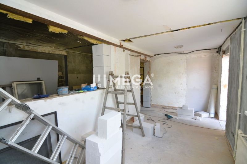 Produktionsräume im Bau mit einer Leiter und Baumaterialien, Boden mit Holzdekor.