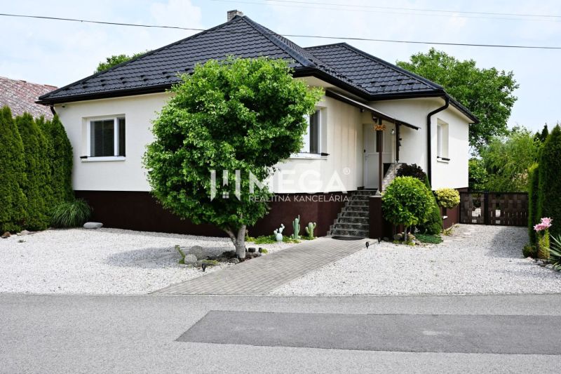 Ein Einfamilienhaus in Udavské mit einem gepflegten Garten, einem Gehweg und Ziersträuchern.
