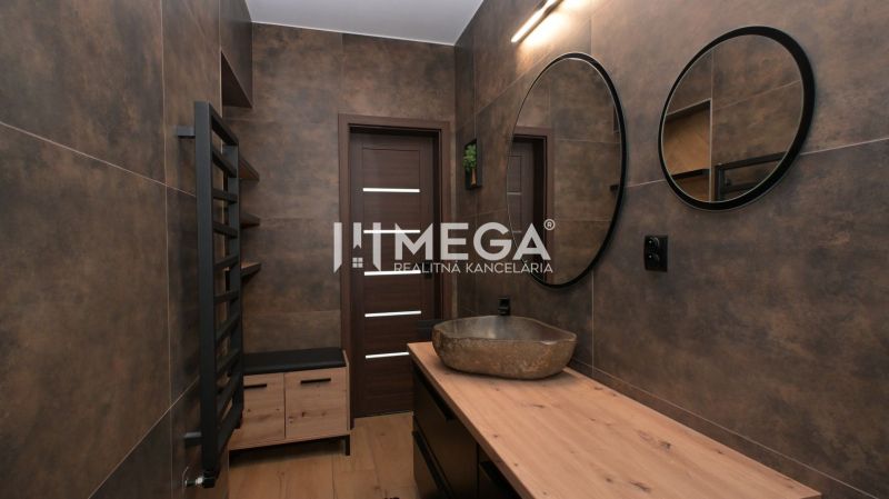 Badezimmerinterieur in einem Einfamilienhaus mit Spiegel, Waschbecken und Boden mit Holzdekor.