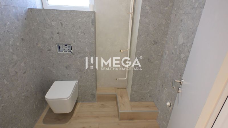 Toilette mit Holzboden und grauen Fliesen in Geschäftsräumen.