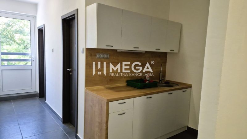 Küchenecke im Büro mit Holzdekor und großem Fenster.